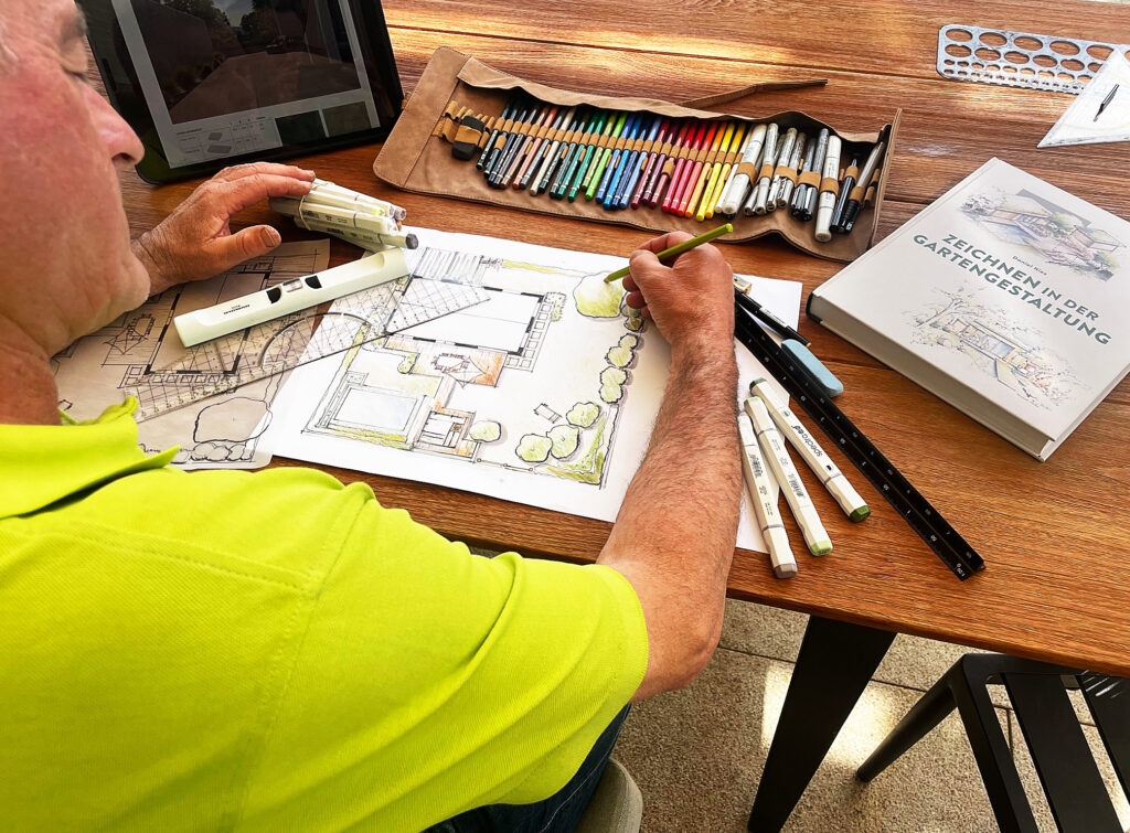 Bild zeigt den Chef beim Zeichnen einer Gartenanlage für ein Kundenangebot.